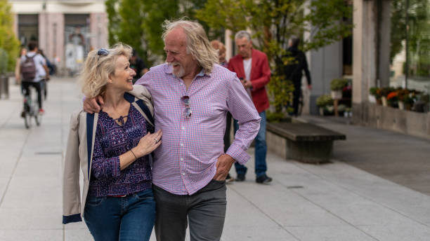 istock Senior couple laughing while walking on the street 1200781263