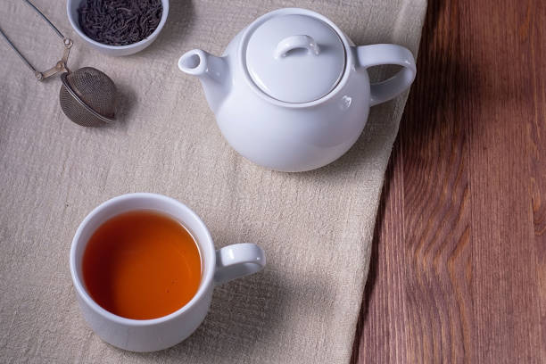 istock Tea. Cup of tea and teapot on a dark wooden table. Top view, copyspace 1200783432