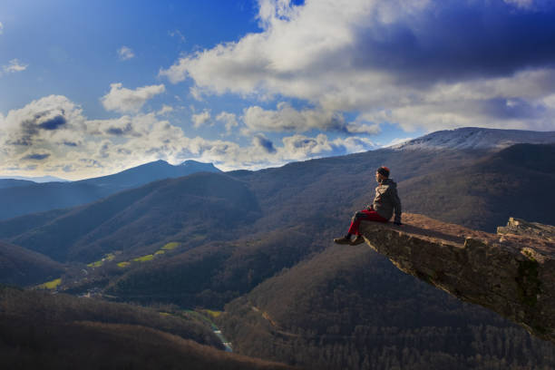 homme appréciant le paysage s'asseyant sur un rocher dépassant de la montagne, mirador de zamariain dans la vallée d'arce, navarre - climbing rock climbing rock mountain climbing photos et images de collection