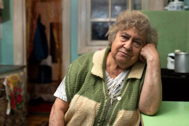 istock Lonely poor elderly woman at home in the kitchen 1200784596