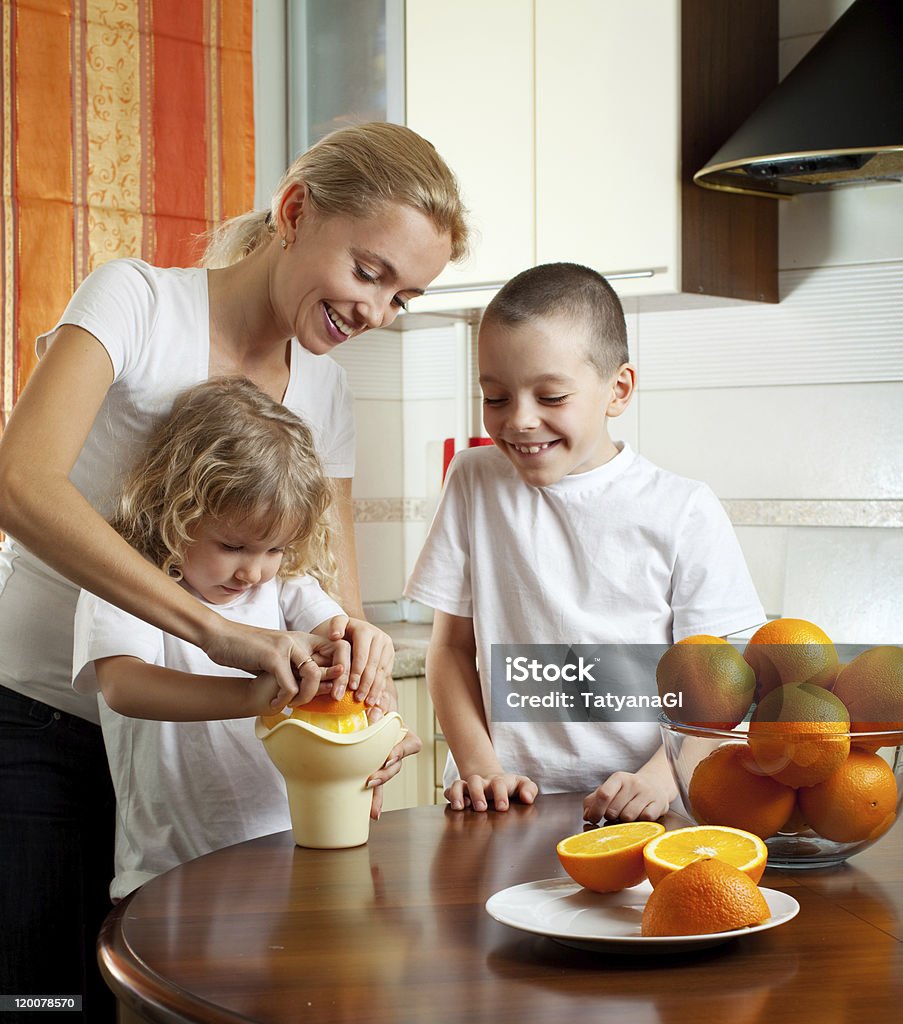 Mother with children squeezed orange juice Happy mother with children squeezed orange juice Adult Stock Photo