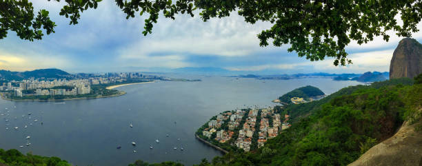 vista surpreendente de rio de janeiro, distrito de urca, montanha do naco de açúcar, oceano azul, iate, edifícios, litoral e montes tropicais da floresta húmida em brasil, rio. - rio de janeiro guanabara bay residential structure urca - fotografias e filmes do acervo