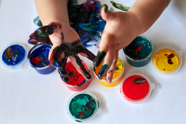 istock The child shows dirty hands after drawing with finger paints 1200786821