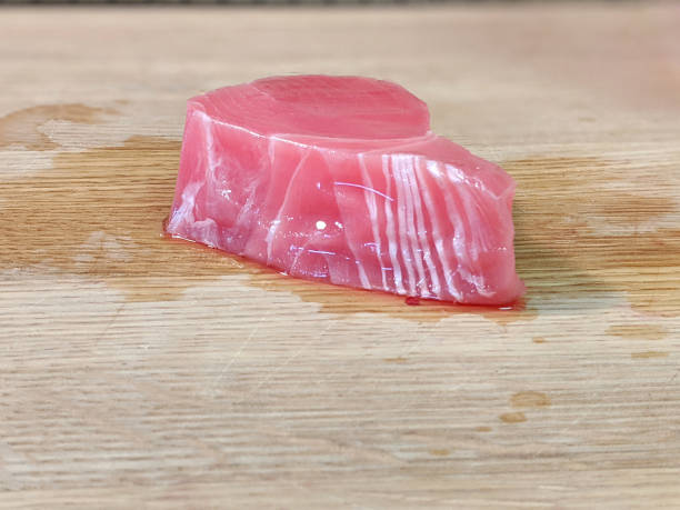 filé de atum ahi rosa fresco e rosa não embalado em cima de uma tábua de corte de bambu de madeira - prepared ahi tuna seared portion - fotografias e filmes do acervo