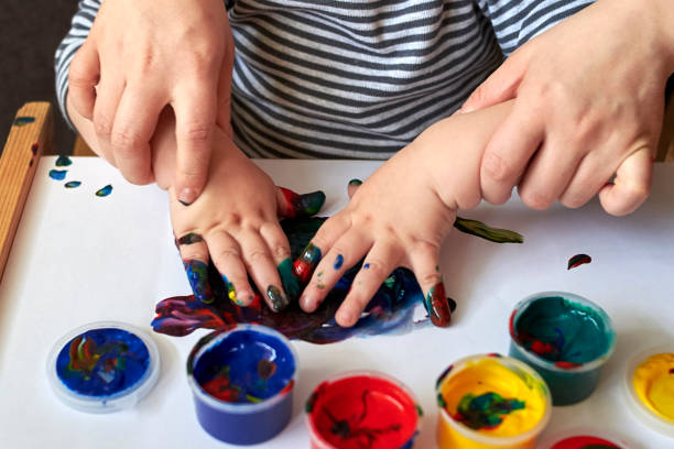 엄마는 아이에게 손가락 페인트로 그리라고 가르칩니다. - 감각 지각 뉴스 사진 이미지