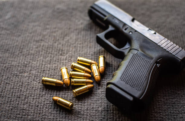 istock bullets and gun on black velvet desk 1200787003