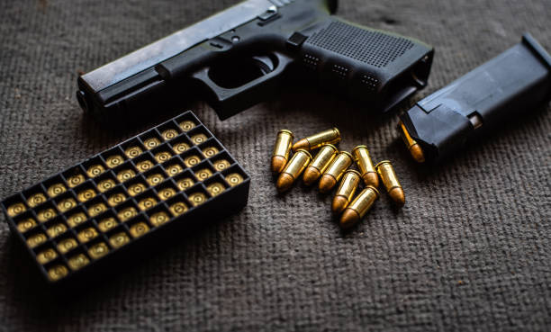 istock bullets and gun on black velvet desk 1200787044