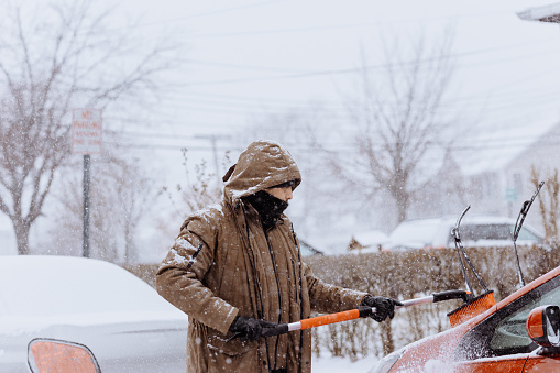 Cleaning a car covered by snow using a proper tool