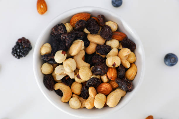 Nuts and berries are scattered on the table. nuts are in the plate. stock photo