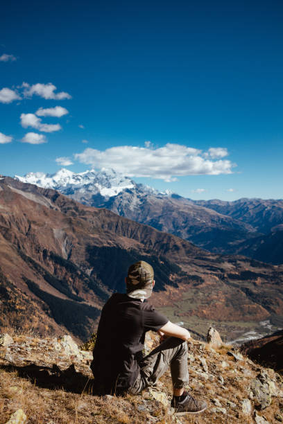istock Caucasian man take a relax sitting on the rock with mountain view 1200796997