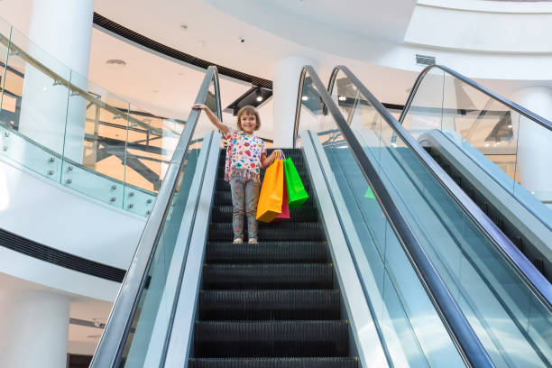エスカレーターで購入した小さな女の子 - escalator child shopping mall little girls ストックフォトと画像