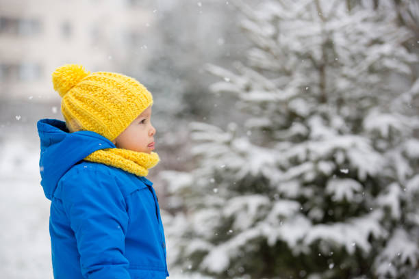 istock Sweet toddler boy, playing with snow on playground 1200798053