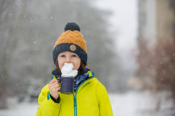 istock Sweet toddler boy, playing with snow on playground 1200798418
