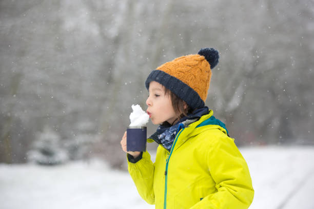 istock Sweet toddler boy, playing with snow on playground 1200799021