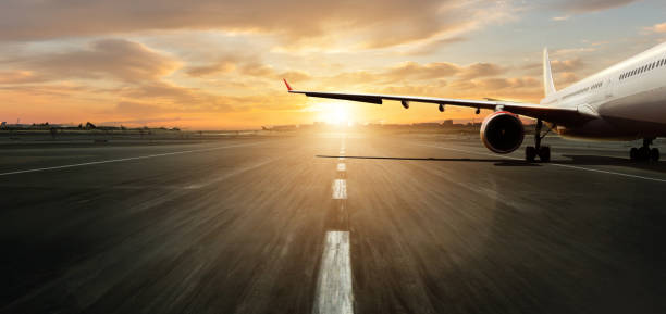 avion stationné sur la piste avec le coucher du soleil dramatique - wheel airplane landing air vehicle photos et images de collection