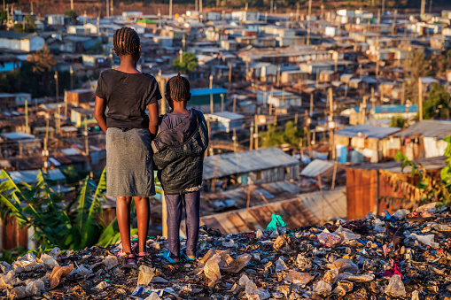 Niñas africanas de pie en la basura y mirando a la barriada de Kibera, Kenia, photo