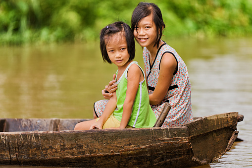 Two Vietnamese young girls on the boat in the Mekong river delta, Vietnam.