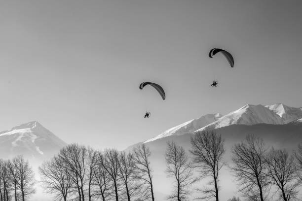 Two moto paragliders in the beautiful mountain in the winter black and white