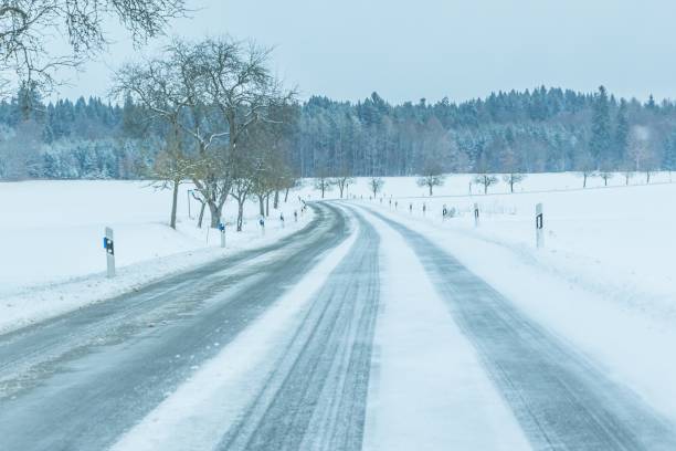 tráfego solitário de estrada de inverno gelada com pista branca de neve - car winter road reflector snow - fotografias e filmes do acervo
