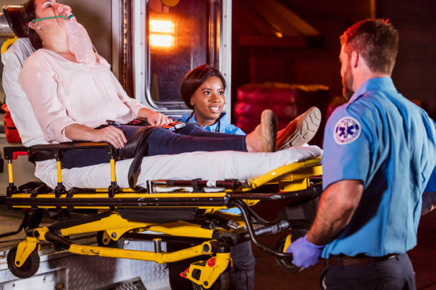 istock Paramedics loading woman on stretcher into ambulance 1200805994