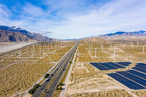 A field of solar panels and windmills in the desert.