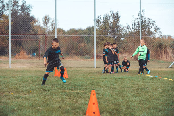 istock Boy of School Junior Soccer Team Practicing on Grass Field 1200806470