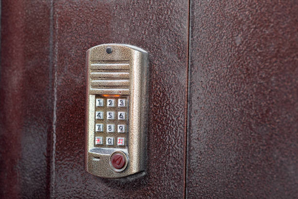 istock intercom with a microphone and speaker and a keypad for dialing and a scanner chip key for access on iron doors, with copy space 3/4 view close up. 1200809077