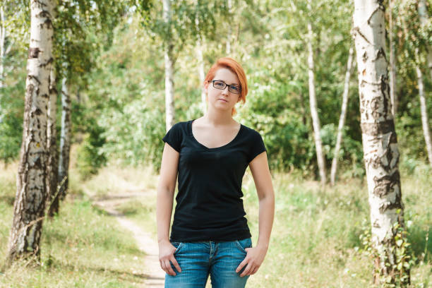 istock Beautiful ginger woman in summer birch forest. 1200810063