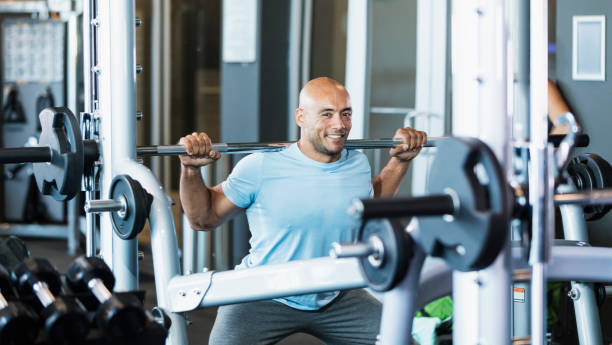 istock Hispanic man working out at gym, lifting barbell 1200812428