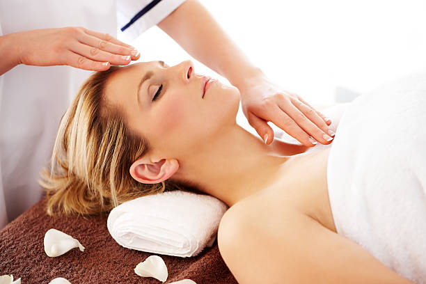 mulher recebendo um tratamento de reiki. - head massage massaging facial massage beautician - fotografias e filmes do acervo