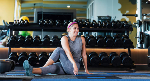 istock Hispanic woman working out at gym, stretching 1200813402