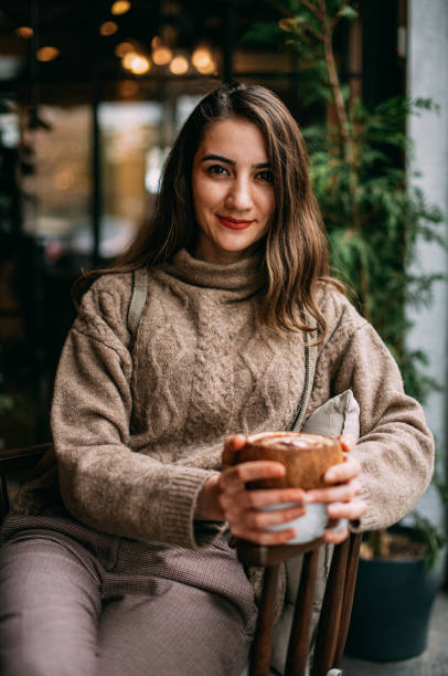 istock Brunette Woman Drinking Coffee in Cafe 1200817571