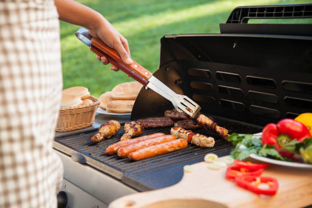 Barbecue grill with meet, vegetables and bread. BBQ with different meat, chicken, sausage, hot-dog, souvlaki and more. Bread and vegetables by the side. Putting meat on the plate. Barbecue man with his meat. barbecue grill photos stock pictures, royalty-free photos & images