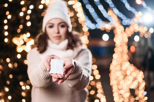 istock Girl hold hand warmers on night lights background. 1200818967