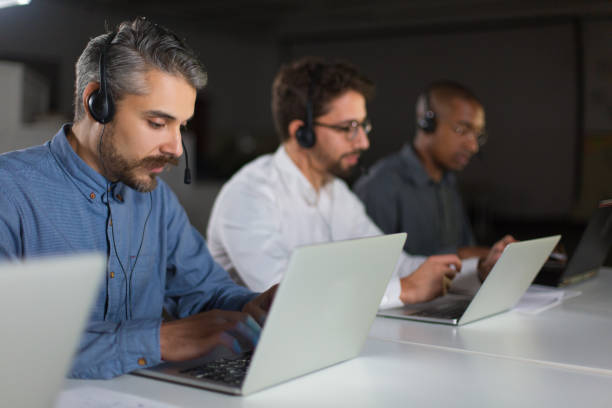 istock Handsome young man with headset typing on laptop 1200820783