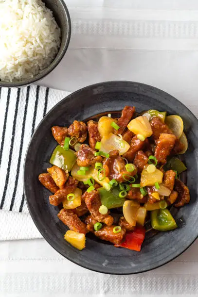 Sweet and sour pork from above. Deep fried meat is added to stir fried pineapple, onions, peppers and sauce. Sweet and sour dishes are common in asian cuisine, especially American Chinese food.