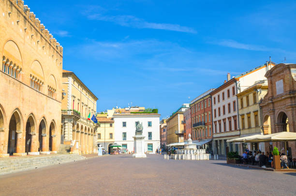 Old colorful multicolored building and houses and Pope Paul V monument on Piazza Cavour square in historical touristic city centre Rimini with blue sky background, Emilia-Romagna, Italy stock photo