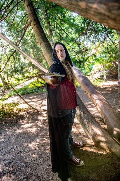 istock Young man Larping as a Knight wearing a cape and holding a sword 1200831187