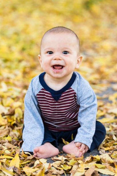 istock Baby boy smiling in yellow fall leaves 1200831855