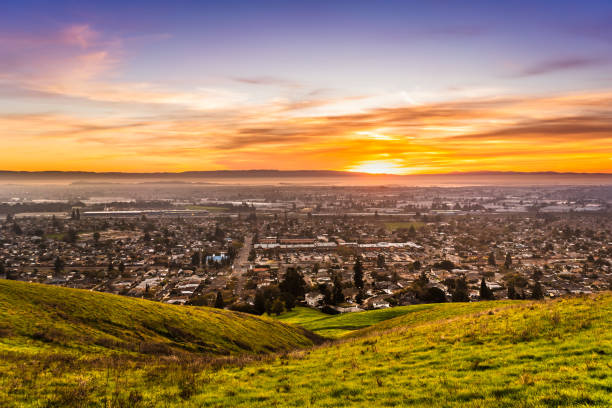 sunset view of residential and industrial areas in east san francisco bay area; green hills visible in the foreground; hayward, california - san francisco bay area community residential district california imagens e fotografias de stock