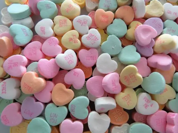 Photo of Heart-shaped conversation candies, background, copy space