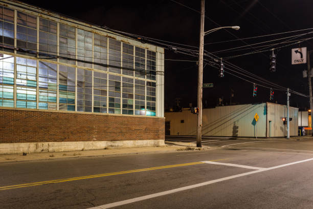 istock Looking at a street corner in a warehouse district at night with multicolored windows 1200845264
