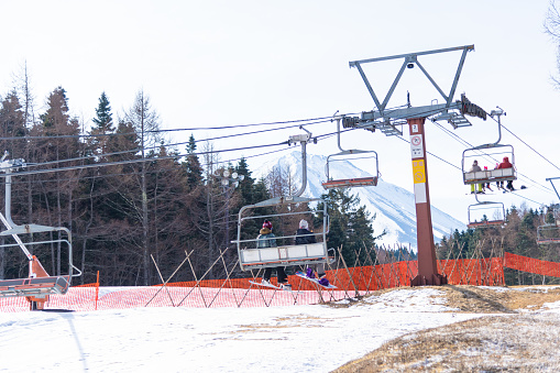 Yamanashi, Japan March 12,2017: Mount Fuji view, Crowd tourists enjoy of ski resort, slope snow valley pine, Fujiyama Top beautiful in Japan beautiful landscape in winter time at Fujiten ski resort