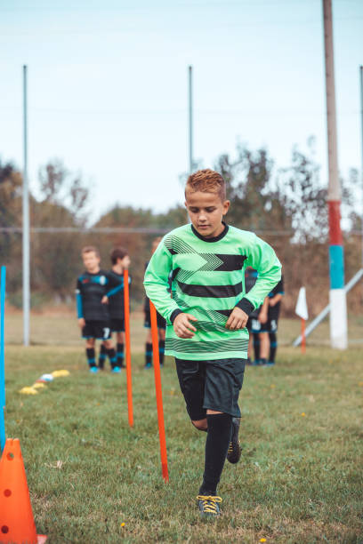 istock Young soccer player running between cones and ring ladder marker 1200857336