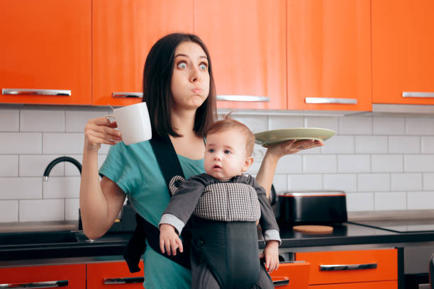 istock Busy Multitasking Mom with Baby, Coffee Mug and Dishes 1200860682