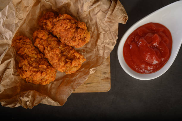 istock Crispy fried chicken on a cutting board with tomato sauce, Top view. 1200861483