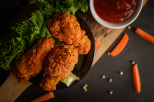 istock Crispy fried chicken on a cutting board with tomato sauce and carrot, Selective focus. 1200861498