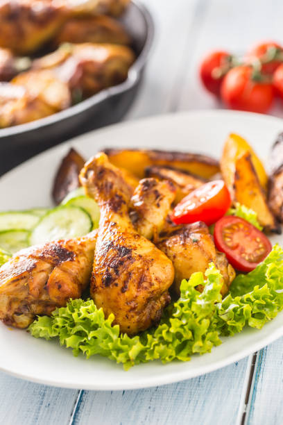 istock Roasted chicken legs with lettuce salad and tomatoes 1200862640