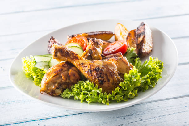 istock Roasted chicken legs with lettuce salad and tomatoes 1200862655