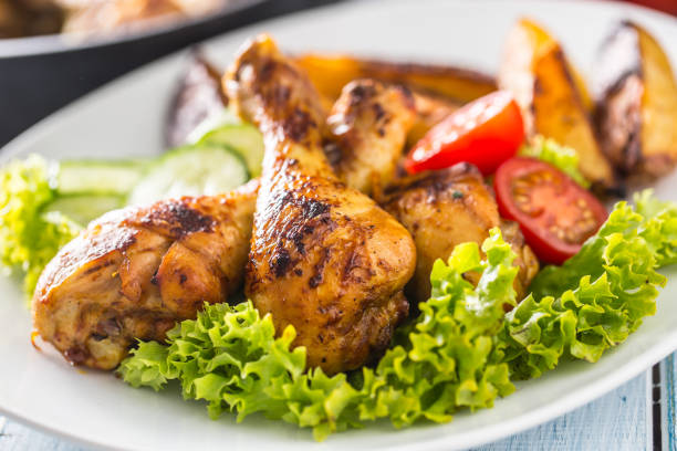 istock Roasted chicken legs with lettuce salad and tomatoes 1200862656